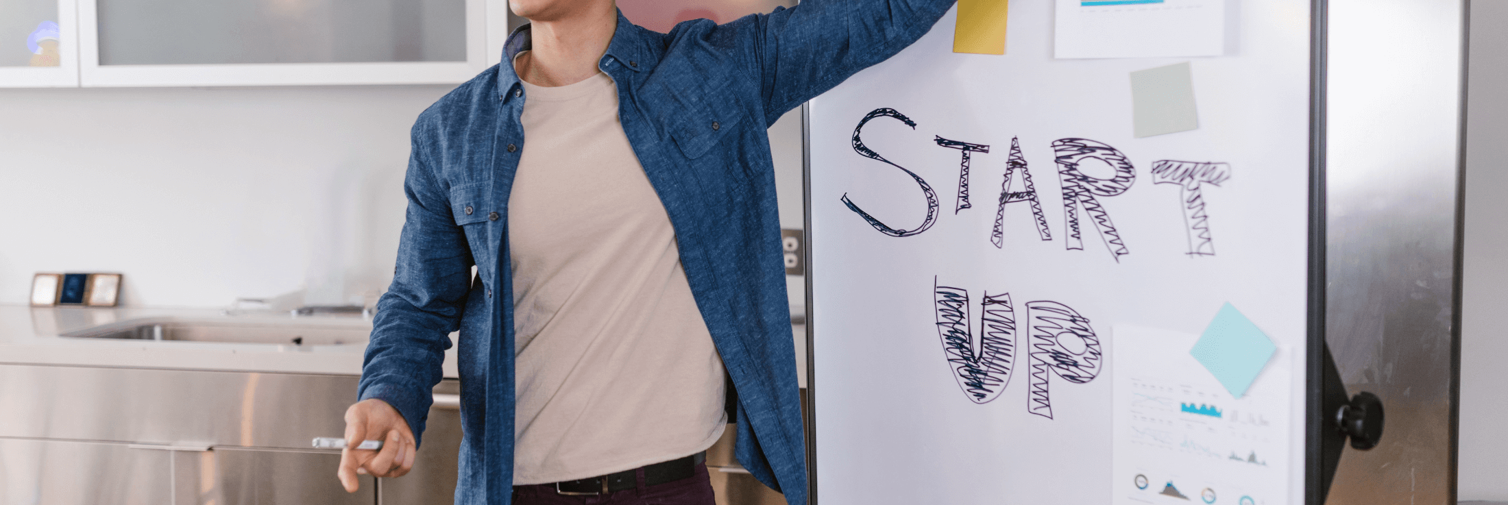 portugal start up a photograph of a young entrepreneur in front of white board which contains the text start up